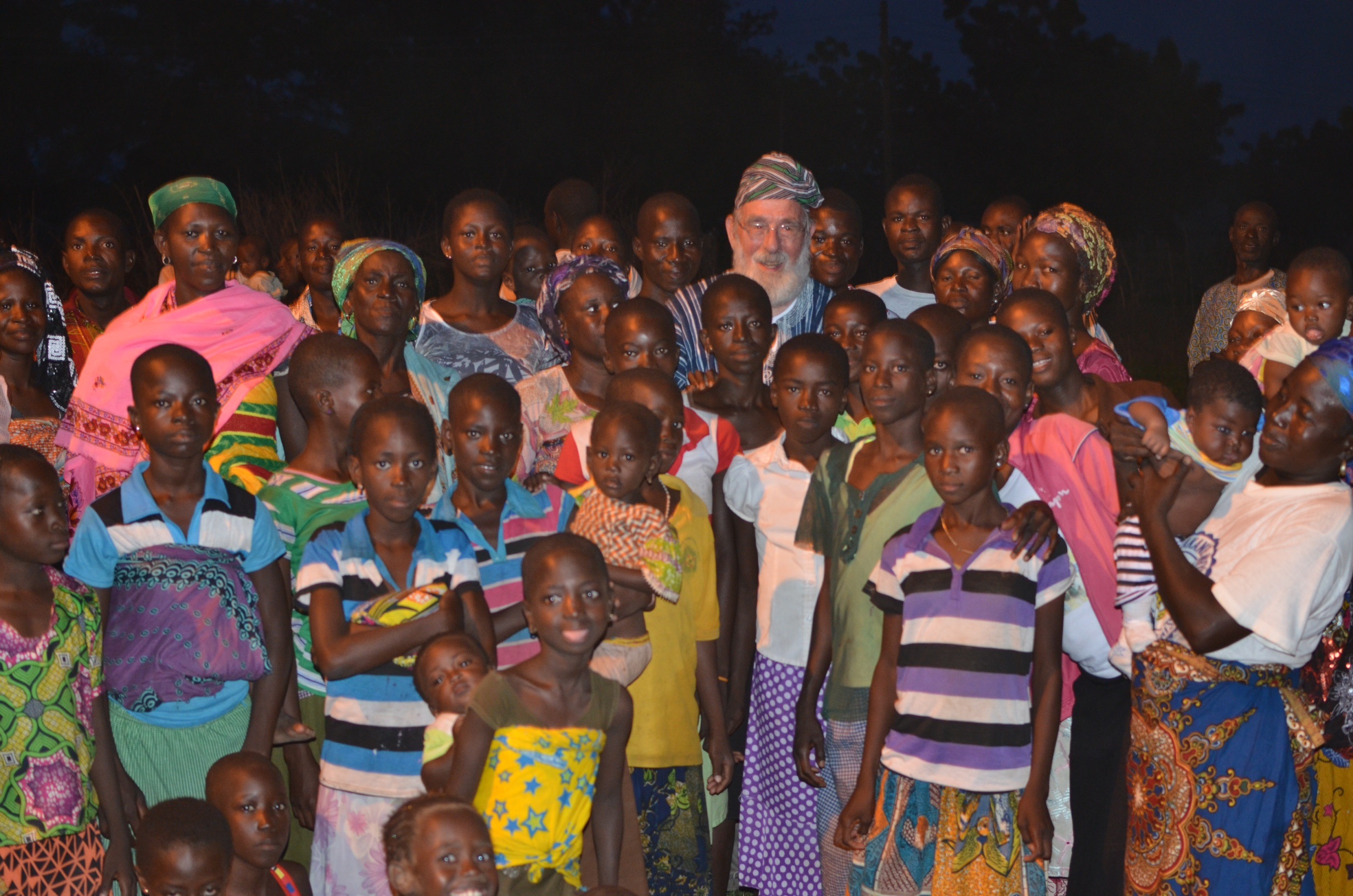 Atze van den Broek te midden van vrouwen en kinderen in Noord-Ghana